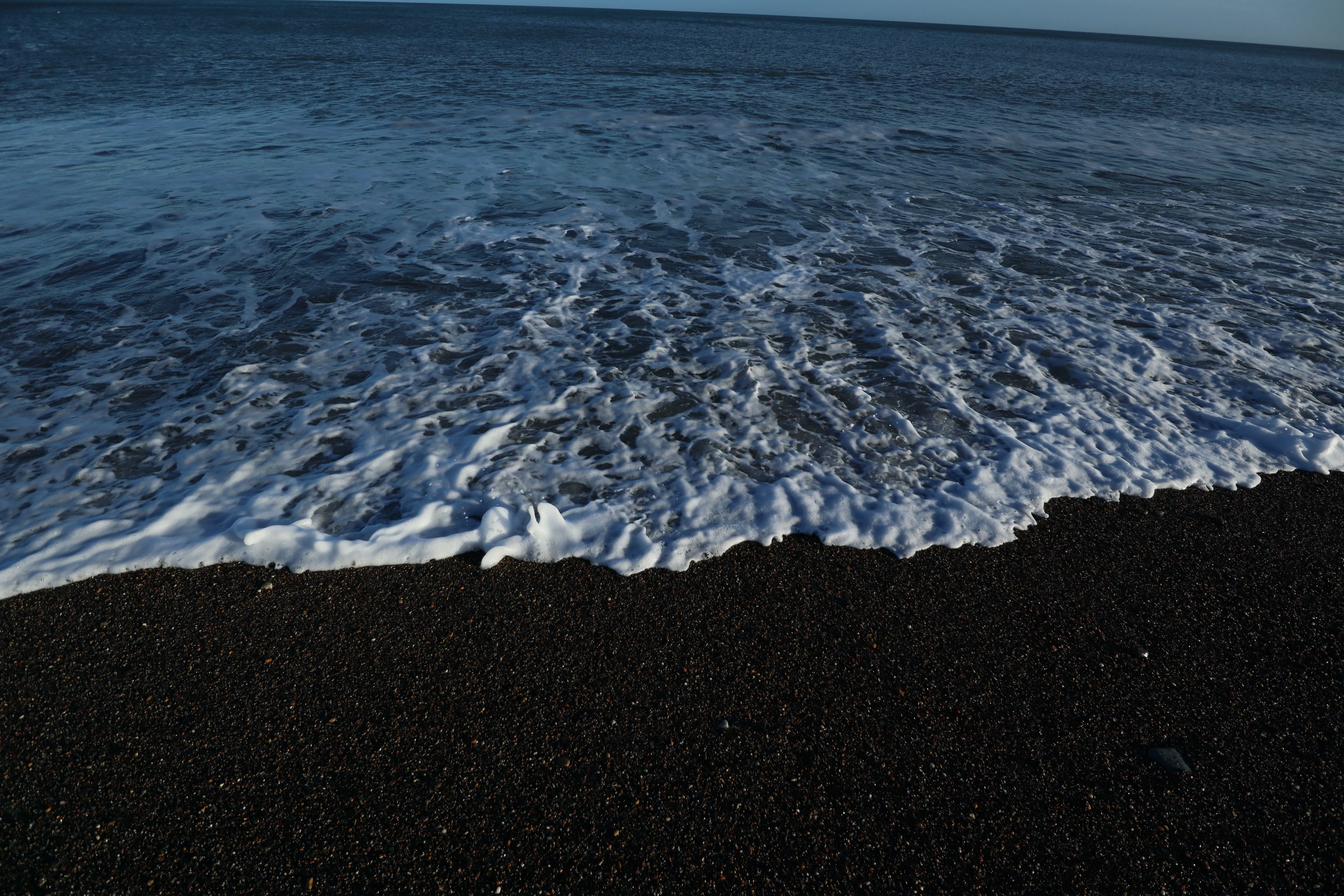 Black sand beach with rolling waves